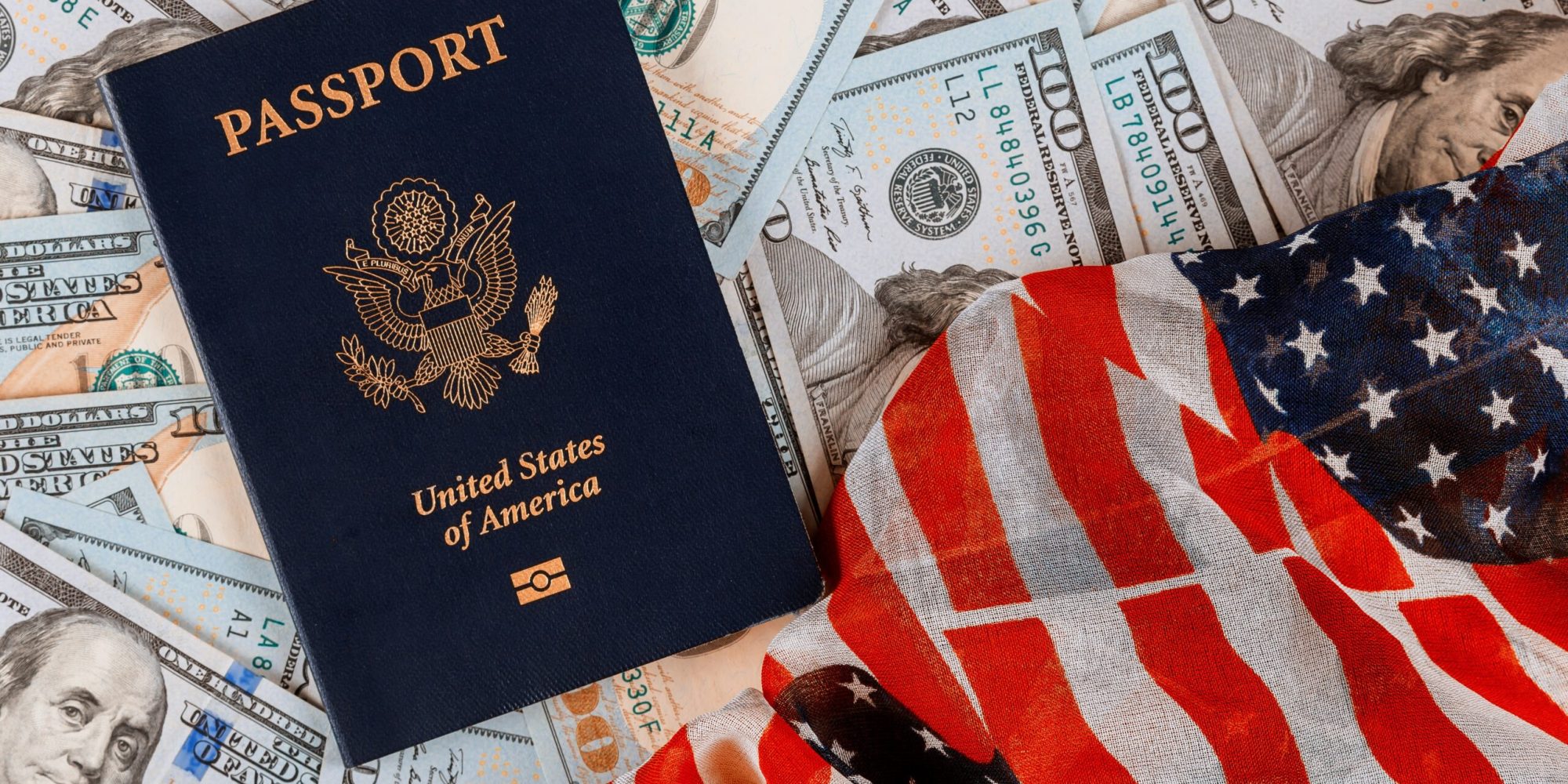 Patriotic USA passport on top of a pile of one hundred US banknote currencies on American flag